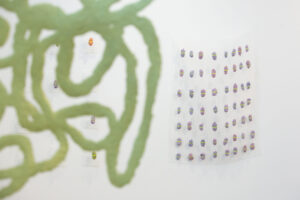 Abstract stitching green on white textile with grid of dots