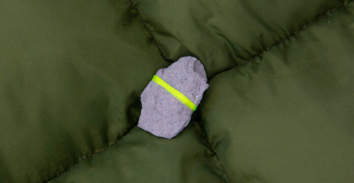 Bound textiles on a green cushion.